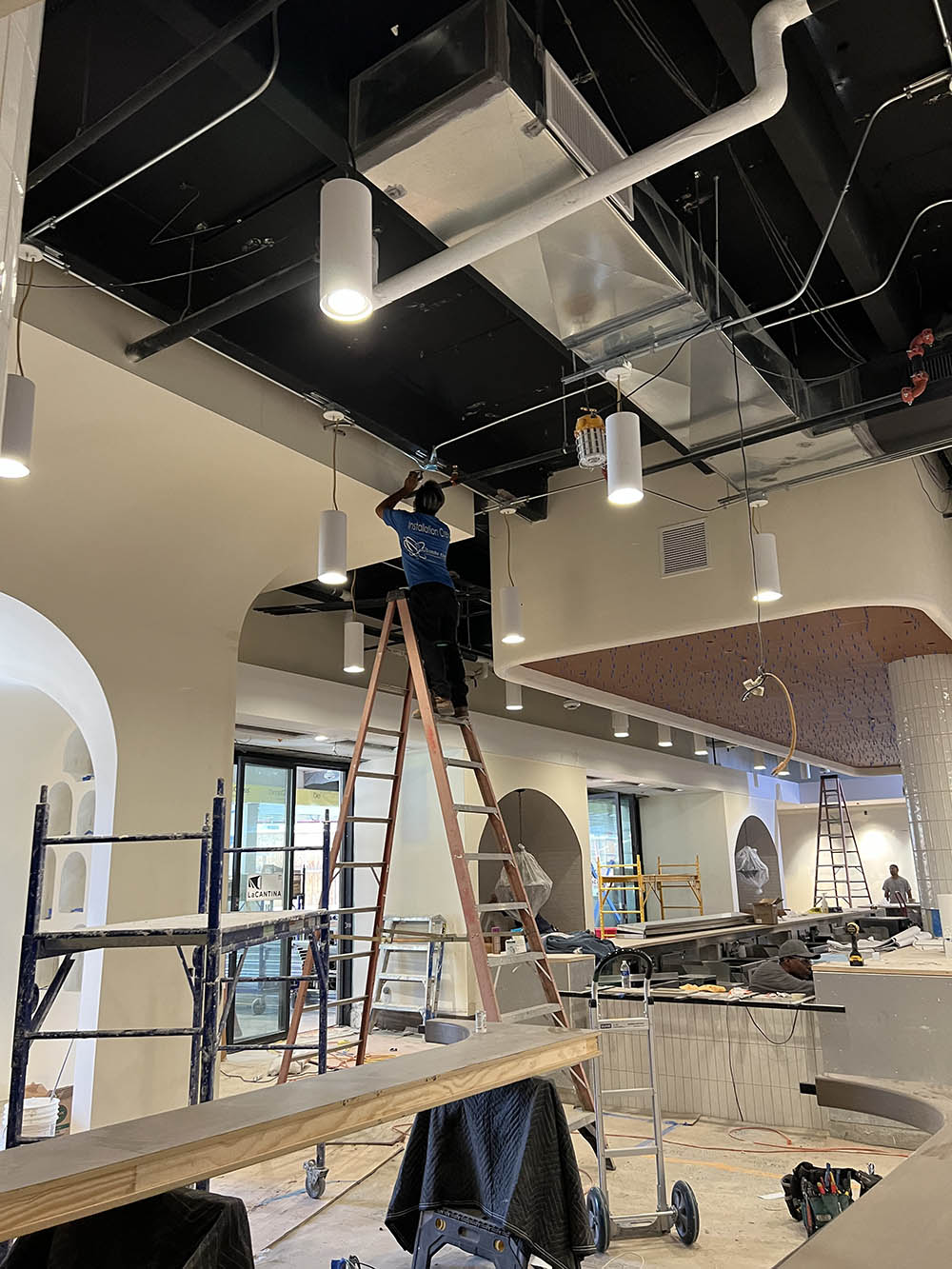 Our dedicated team member skillfully installs state-of-the-art lighting fixtures, enhancing the ambiance of a local restaurant. At Coulombs Electric, we're not just installing lights; we're elevating experiences, one fixture at a time.